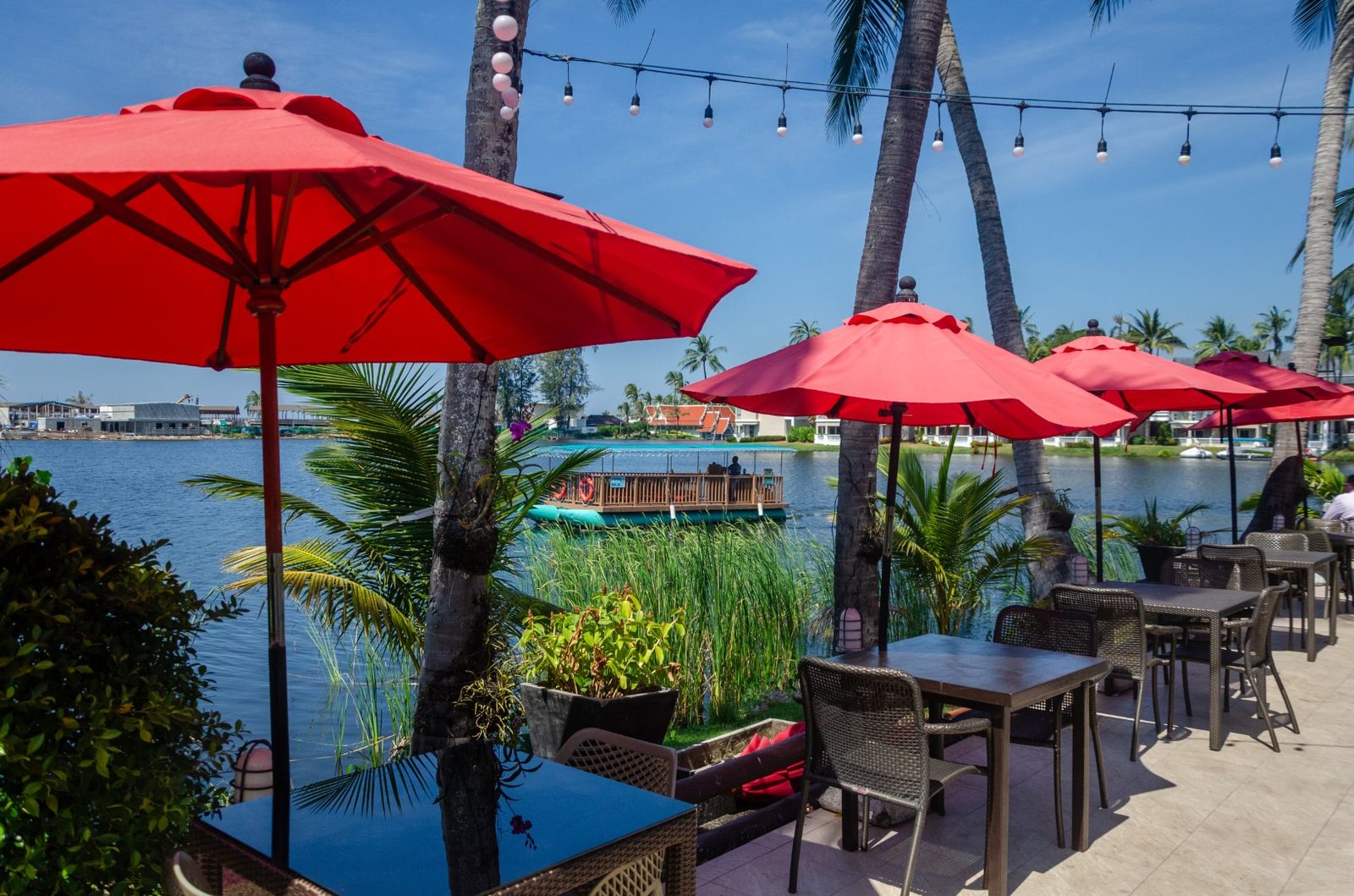 Red umbrellas on the lakeside terrace of Albatross Café